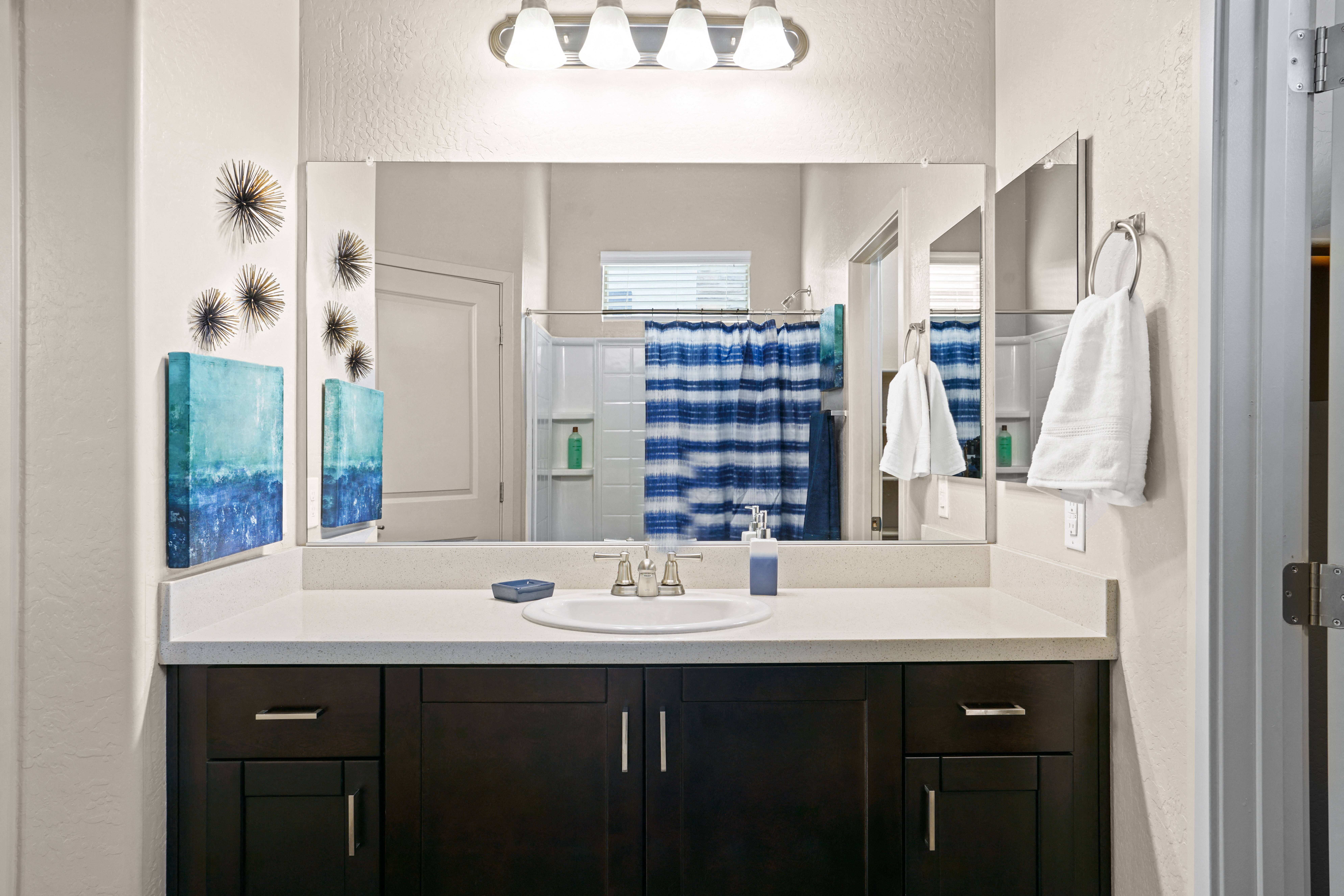 a bathroom with a sink and a mirror at Olive Queen Creek Apartments, Queen Creek, Arizona